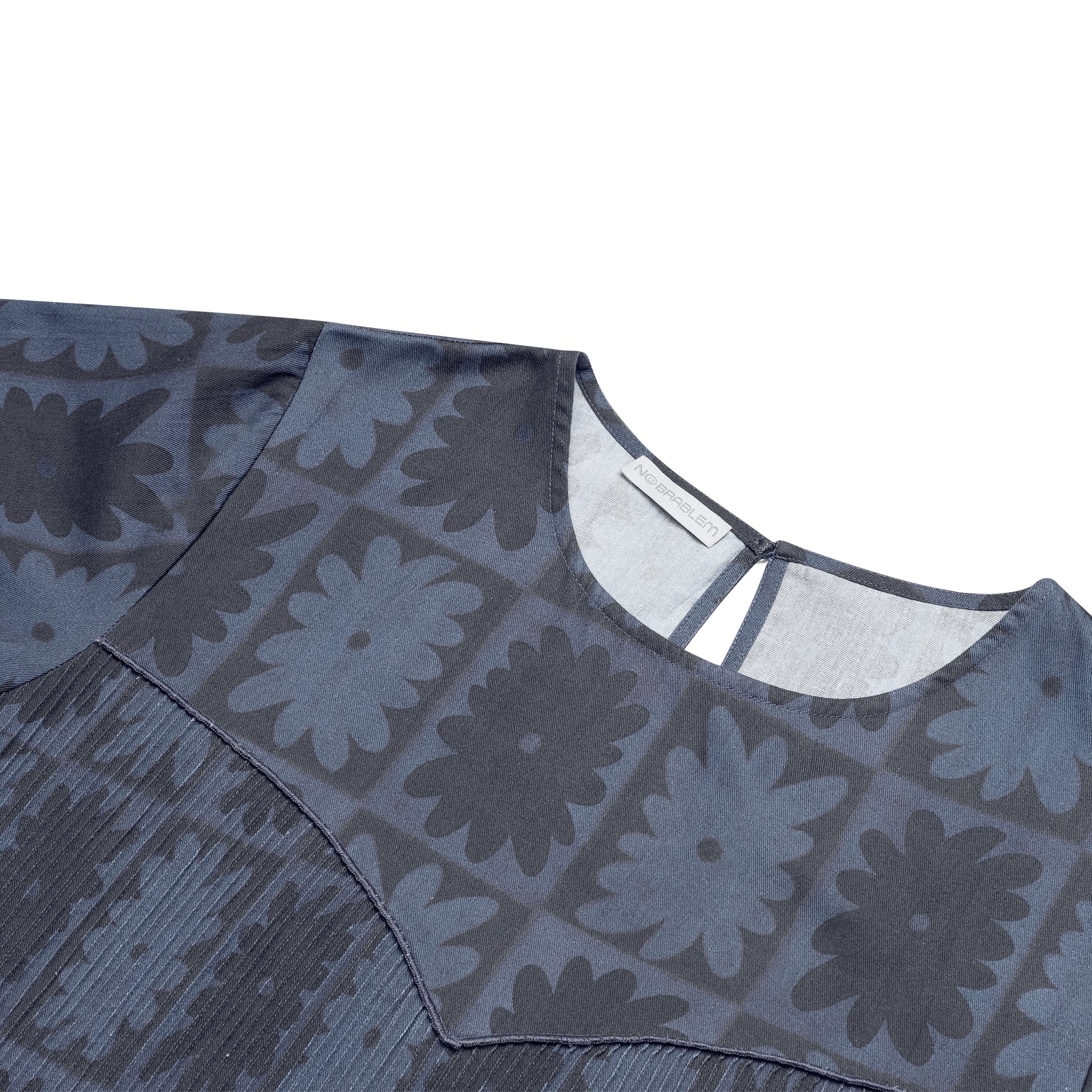 Close-up of the BFF Checkered Floral Top's pleated front panel, highlighting the bold floral checkered pattern in black and dark grey on soft cotton fabric.