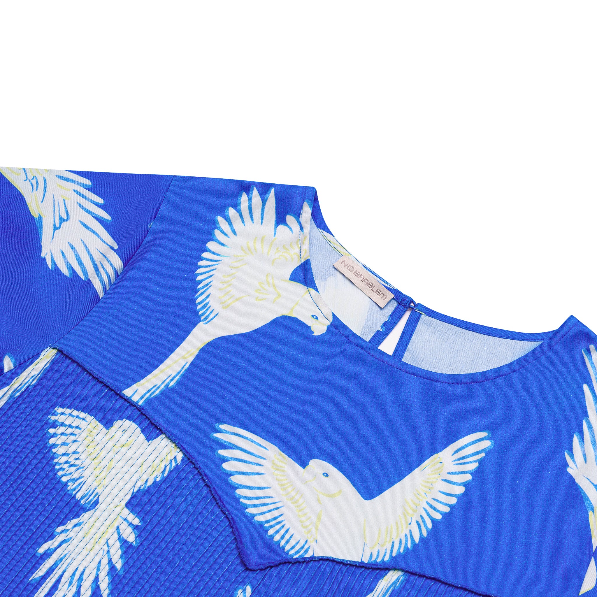 Close-up shot of the Bra-Free Forever (BFF) Bird Top, highlighting the bold white bird motifs on a soft blue background. The top features a pleated front panel, designed for a comfortable, bra-free fit with a stylish and minimalistic look.