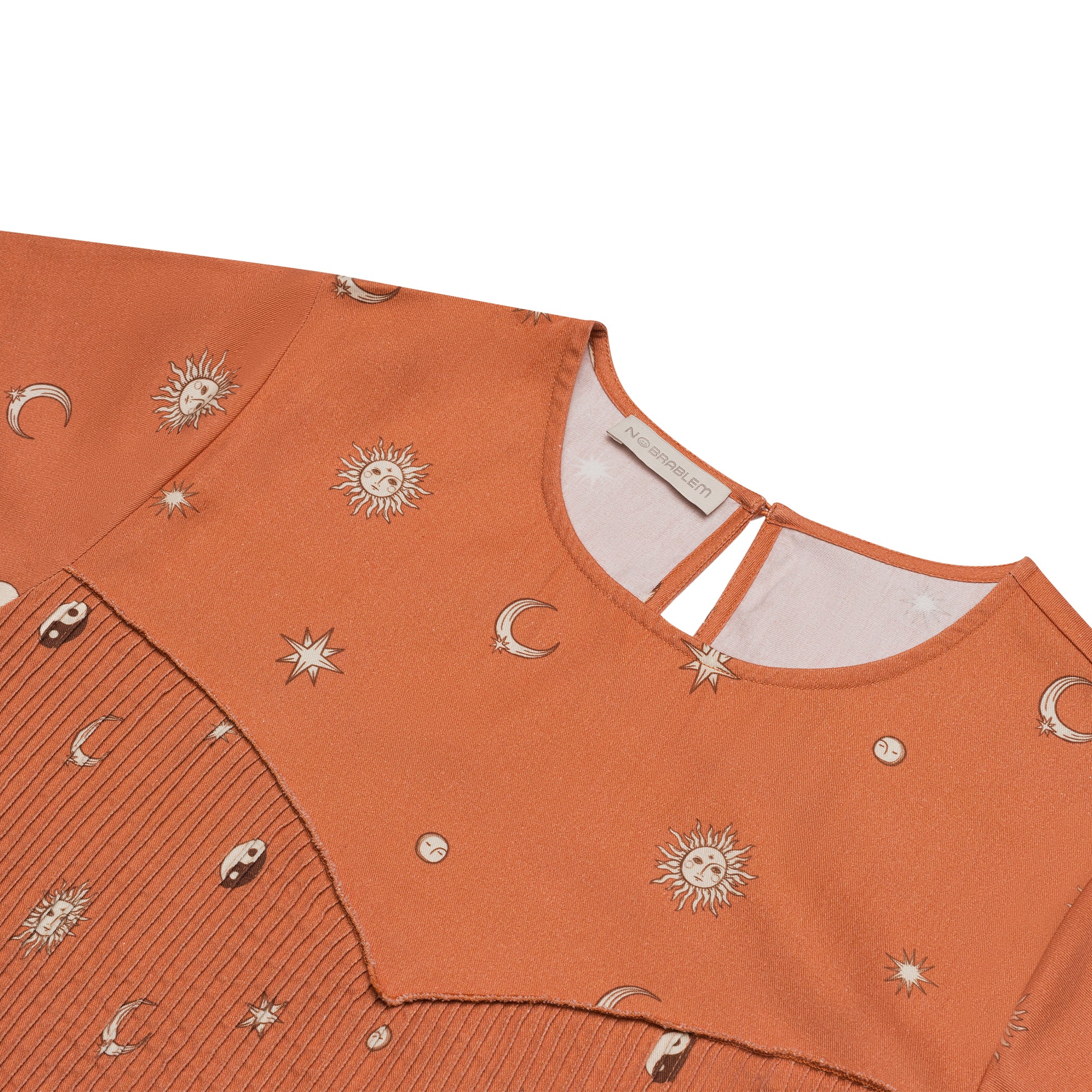 Closeup view of the Bra-Free Forever (BFF) Mystic Top, featuring a terracotta-colored, earthy pattern inspired by the moon, stars, and yin-yang symbols. Designed for a comfortable, bra-free fit, this top combines energy and balance with a unique, boho-inspired style. Perfect for everyday wear with a relaxed, oversized silhouette.